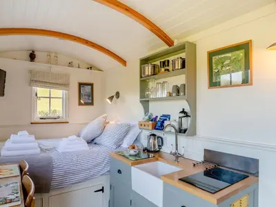 a kitchen with a bed in a small room at Shepherds Retreat in St Austell