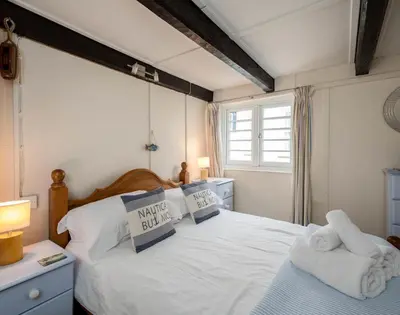 a bedroom with a white bed with towels on it at St Samson in Port Isaac