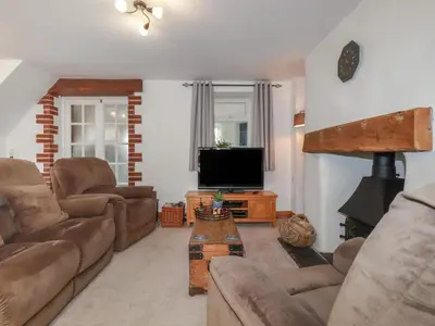 a living room with a couch and a tv at Miners cottage in St Austell