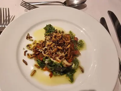 a white plate of food with broccoli on a table at Wayfarers Inn in Penzance