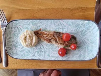 a plate of food with meat and tomatoes on a table at Wayfarers Inn in Penzance