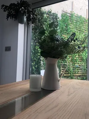 a white vase sitting on a table with a plant at The Nest, Central Falmouth, 10 mins to the beaches and off street parking in Falmouth