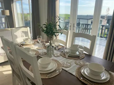 a dining room table with a table set with plates and glasses at No14 Padstow in Padstow