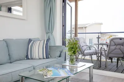 a living room with a couch and a table at Fistral View, Pentire - Parking, Sea view, free Wifi in Newquay