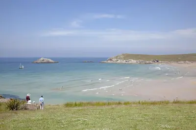 two people standing on a beach near the ocean at Fistral View, Pentire - Parking, Sea view, free Wifi in Newquay