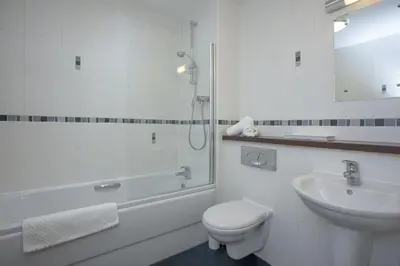 a bathroom with a toilet and a sink and a shower at Fistral View, Pentire - Parking, Sea view, free Wifi in Newquay