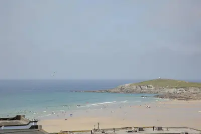 a group of people on a beach near the ocean at Fistral View, Pentire - Parking, Sea view, free Wifi in Newquay
