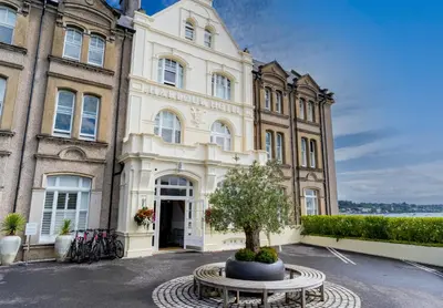 a building with a tree in front of it at Harbour Hotel Padstow in Padstow