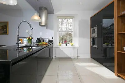 a kitchen with a black counter and a window at Arghanti in St Ives