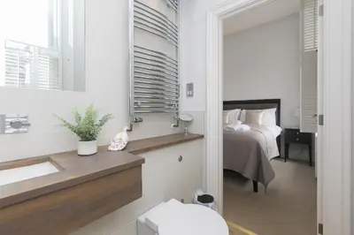 a bathroom with a sink and a bedroom with a bed at Arghanti in St Ives