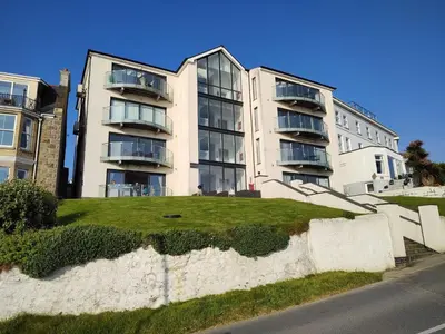 an apartment building with a lawn in front of it at No 1 Oceans in Perranporth
