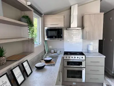a small kitchen with a stove and a microwave at Porthcurno 4, Silverbow Country Park in Perranzabuloe