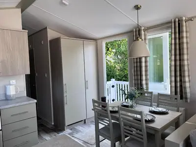 a kitchen and dining room with a table and chairs at Porthcurno 4, Silverbow Country Park in Perranzabuloe