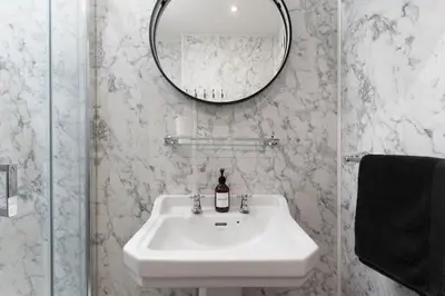a bathroom with a white sink and a mirror at Peaceful & Tranquil Cottage With Private Terrace at 'The Pink House' in Falmouth