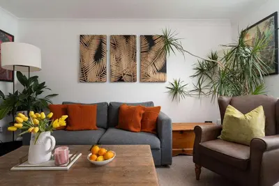 a living room with a couch and a table at Peaceful & Tranquil Cottage With Private Terrace at 'The Pink House' in Falmouth