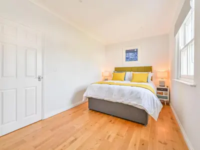 a white bedroom with a bed and a window at Holiday Home Sea Breeze by Interhome in St Austell