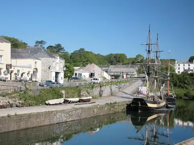 a boat is docked in the water next to a harbor at Holiday Home Sea Breeze by Interhome in St Austell