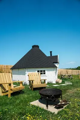 a white house with a grill and two wooden chairs at Mawgies in Saint Ervan
