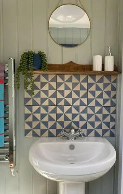 a bathroom with a white sink and a mirror at Olive's Cabin in Helston