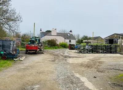 a truck parked on a dirt road in a village at Olive's Cabin in Helston