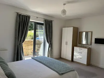 a bedroom with a bed and a large window at The Waterwheel Apartment, Charlestown in Charlestown