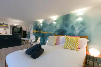 a bedroom with a large white bed with colorful pillows at Island Studio with on-site parking in St Ives