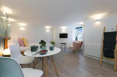 a living room with a white table and chairs at Island Studio with on-site parking in St Ives