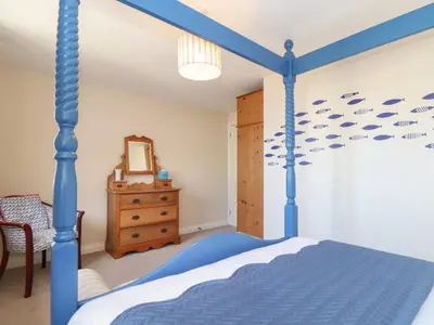 a bedroom with a blue bed with fishes on the wall at Kingsholm in Truro