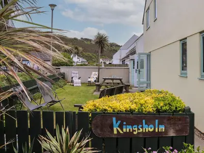 a garden with a bench and flowers in a yard at Kingsholm in Truro