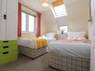 two beds in a room with two windows at Kingsholm in Truro