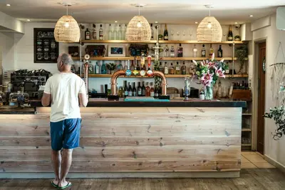 a man standing at a bar at The Potting Barn in Saint Ervan