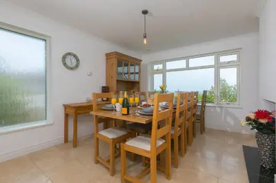 a dining room with a wooden table and chairs at Moonbeams in St Ives
