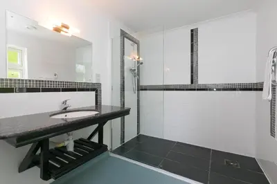 a white bathroom with a sink and a shower at Moonbeams in St Ives