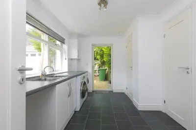 a white kitchen with a sink and a dishwasher at Moonbeams in St Ives