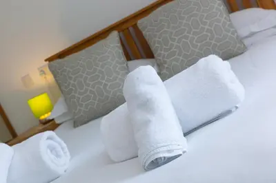 a hotel room with towels on a bed at Moonbeams in St Ives
