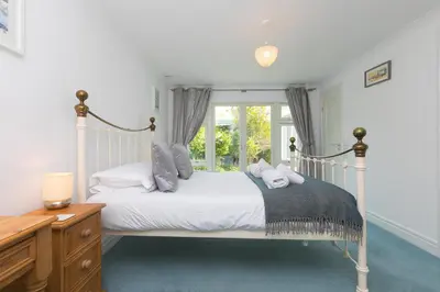 a bedroom with a white bed and a window at Moonbeams in St Ives