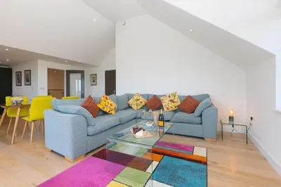 a living room with a blue couch and a colorful rug at Bay View in St Ives