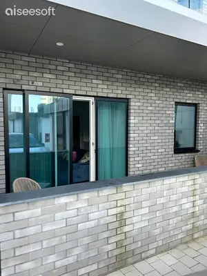 a brick building with windows and chairs on a sidewalk at Beachside Apartment in Newquay