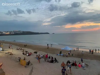 a group of people on the beach at sunset at Beachside Apartment in Newquay