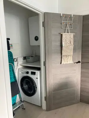 a door to a laundry room with a washing machine at Beachside Apartment in Newquay