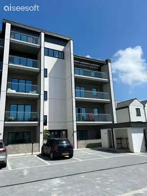a car parked in a parking lot in front of a building at Beachside Apartment in Newquay