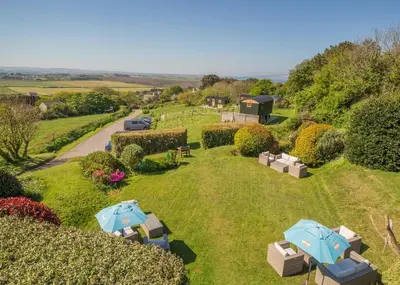 an aerial view of a garden with umbrellas at Beacon Shepherd Huts in St. Agnes