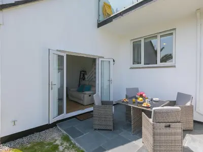 a patio with a table and chairs and a room at Millies in St Ives