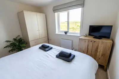 a bedroom with a large white bed with two towels on it at The Bright House, St Eval - near Padstow, Mawgan Porth, Watergate, Bedruthan & Porthcothan in Saint Ervan