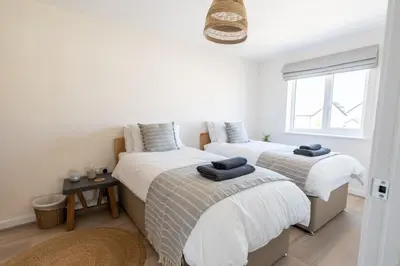 a bedroom with two beds and a window at The Bright House, St Eval - near Padstow, Mawgan Porth, Watergate, Bedruthan & Porthcothan in Saint Ervan