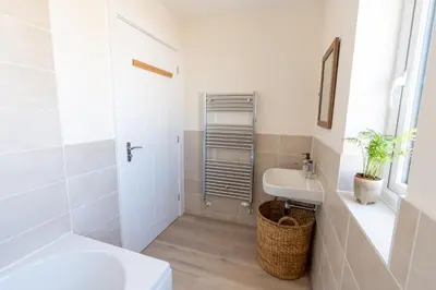 a white bathroom with a sink and a toilet at The Bright House, St Eval - near Padstow, Mawgan Porth, Watergate, Bedruthan & Porthcothan in Saint Ervan