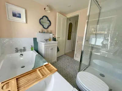 a bathroom with a tub and a toilet and a sink at Enchanting Harbourside Cottage with Panoramic Views in Polruan