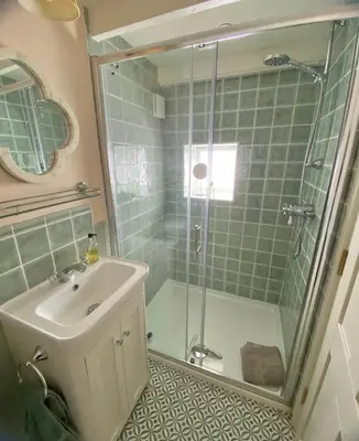 a bathroom with a shower and a sink and a shower at Enchanting Harbourside Cottage with Panoramic Views in Polruan