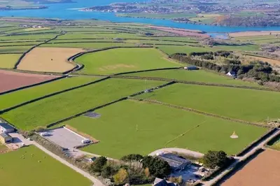 an aerial view of a large field of green grass at Hawk's View Bell Tent at Higher Hawksland Farm in Saint Issey