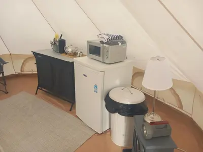 a kitchen with a microwave on top of a refrigerator at Hawk's View Bell Tent at Higher Hawksland Farm in Saint Issey